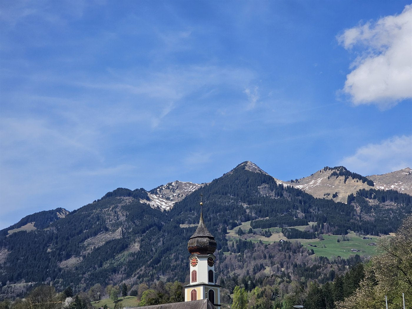 Kirchturm vor Bergkulisse in Vorarlberg